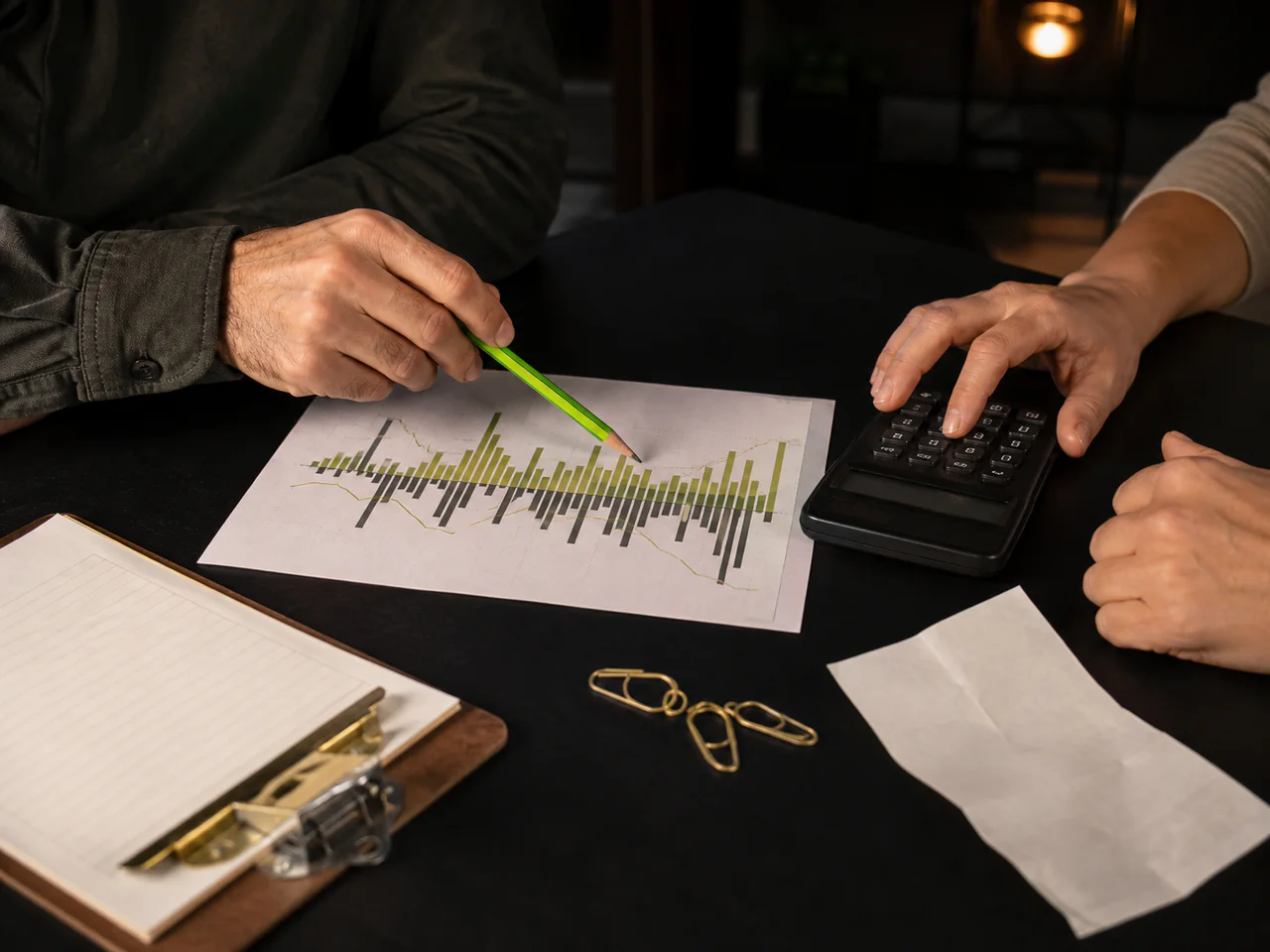 An adviser and owner review an abstract chart and calculator.